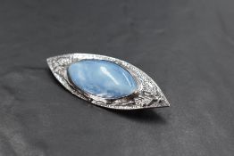 An Artisan style brooch of lozenge form having central oval blue ceramic panel within a silver