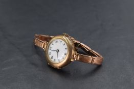 A lady's vintage 9ct rose gold wrist watch having Arabic numeral dial with gilt dots to white enamel