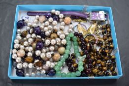 A small selection of costume jewellery including tigers eye beads, a string of baroque pearl and