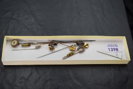 Eleven assorted hat pins of various forms including gold and white metal, diamond and pearl etc