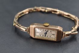 A lady's 9ct rose gold wrist watch having Aabic numeral dial to rectangular face in a gold case with