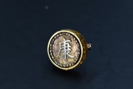 A yellow metal circular brooch having zodiac symbols to perimeter and bearing a Chinese panel to