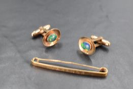 A pair of yellow metal cufflinks stamped 9ct having black opal doublets in oval collared mounts to
