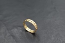 A 9ct gold wedding band having engraved decoration, size Q & approx 2.3g