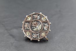 A Victorian silver brooch of circular form having rose and yellow gold inlaid floral decoration,
