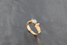 A diamond solitaire ring, approx 0.05ct in an illusionary setting to moulded shoulders on an 18ct