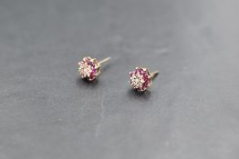 A pair of ruby & diamond chip cluster stud earrings in 9ct gold mounts