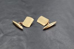 A pair of 9ct gold cufflinks having engine turned panels with chain connecters and lozenge shaped