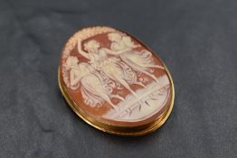 A conch shell cameo brooch depicting the three graces in and 18ct gold mount