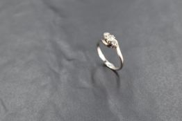 A diamond trilogy ring, total approx 0.35ct having cross over shoulders on a white metal loop