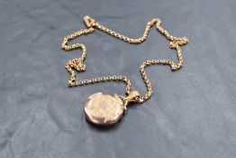 An Edwardian 9ct gold locket and chain, of hinged circular form with engraved detail, marked .375,