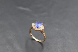A tanzanite and diamond cluster ring, total approx 1.75ct in a raised claw set mount on a 9ct gold