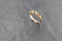 A powder blue sapphire and diamond chip set band ring having a scrolled mount on an 18ct gold