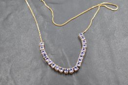 A twenty one stone tanzanite necklace, total approx 4.5ct on a fixed 9ct gold chain, approx 18' &