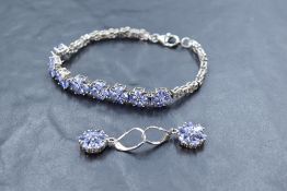 A pair of silver mounted tanzanite cluster earings on loop drops and a similar tanzanite silver