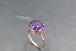 A heat treated amethyst ring in a four claw setting on a 9ct rose gold loop, size S & approx 2.8g