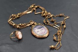 A glass locket with yellow metal mount and bow detail stamped 9ct on a rolled gold decorative chain,