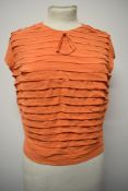 A 1950s orange blouse having tiered/ ruffled detailing to front of bodice with buttons to plain
