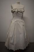 A dramatic 1950s Jean Allen dress in white grosgrain, with one strap, full pleated skirt with faux
