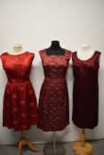 A cherry red 1950s satin dress with floral embroidery and tie belt to waist, a 1950s russet silk