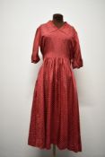 An early 1940s cranberry red and white polka dot day dress, having turn up's to cuffs, side press