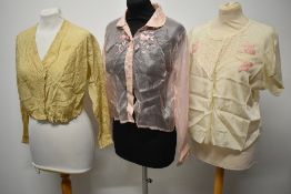 A trio of early 20th century blouses, to include, pink gossamer silk with long sleeves, patterned