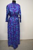 A vibrant 1960s/70s floral feather weight silk jump suit, having wide legged trousers and belt to