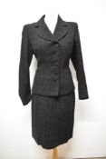 A 1940s skirt suit of black wool with grey fleck, having novelty heart shaped pockets to jacket