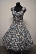 A vintage 1950s cotton sundress, having paisley pattern, full skirt which gathers at hips and rear