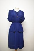 An early 1940s blue crepe day dress having Grecian styling with peplum waist and gold tone