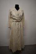 An Edwardian cream silk day dress with cotton lining, full length sleeves trimmed with lace and lace