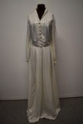 An early 1940s wedding dress having self covered buttons to slightly blouson bodice and sleeves,