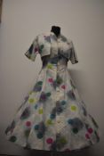 A 1950s cotton day dress and matching bolero jacket, having novelty abstract atomic style print,