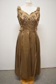 A 1950s taupe coloured satin evening gown with bows to shoulders, sweetheart neckline, bead and