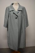 An early 1960s duck egg blue Harrods coat, having single button, two pockets to sides and bracelet