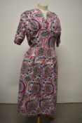 A vibrant 1950s cotton day dress, having V neckline, three quarter sleeves, side metal zip and patch
