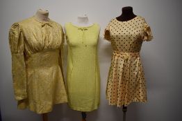 Three 1960s mini dresses, including textured yellow linen like fabric dress and gold tone dress with