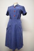 A 1940s blue striped cotton day dress having contrasting red buttons, two deep pockets to front