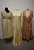 Three early 20th century dresses, including cream silk dress with full length sleeves and stitched