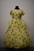 A 1950s yellow cotton day dress having novelty parasol print in pink, black, blue and white with
