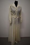 A 1930s wedding dress, having lace edged collar, belted waist, long sleeves with buttons to cuffs