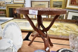 An Indian carved wood table with tripod cat base.