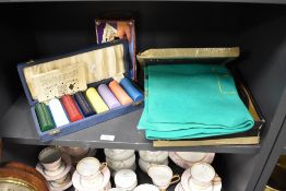 A selection of vintage gambling and roulette items including card shuffler and tokens.