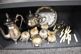 A selection of silver plated tea wares including serving tray, cutlery and tea pots.