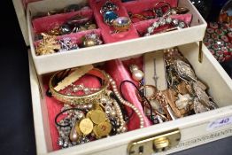 A jewellery box containing a selection of vintage costume jewellery, including loose beads, rings,