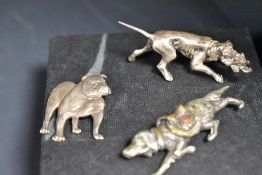 A silver and gold tone setter or flat coat retriever brooch having saddle bag with red cross emblem,