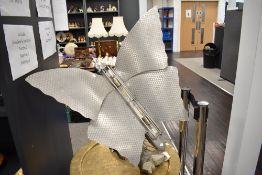 An Art Deco Butterfly form room heater converted into a lamp, in aluminium on a swivel arm branch on