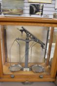 An early 20th century Philip Harris apothecary or chemist scales in a glazed oak case