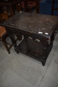 A period oak side table in a gothic style with lunette carving to top, width approx. 69cm