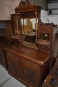 A Victorian oak sideboard having mirror back and carved vase and flower decoration to cupboard